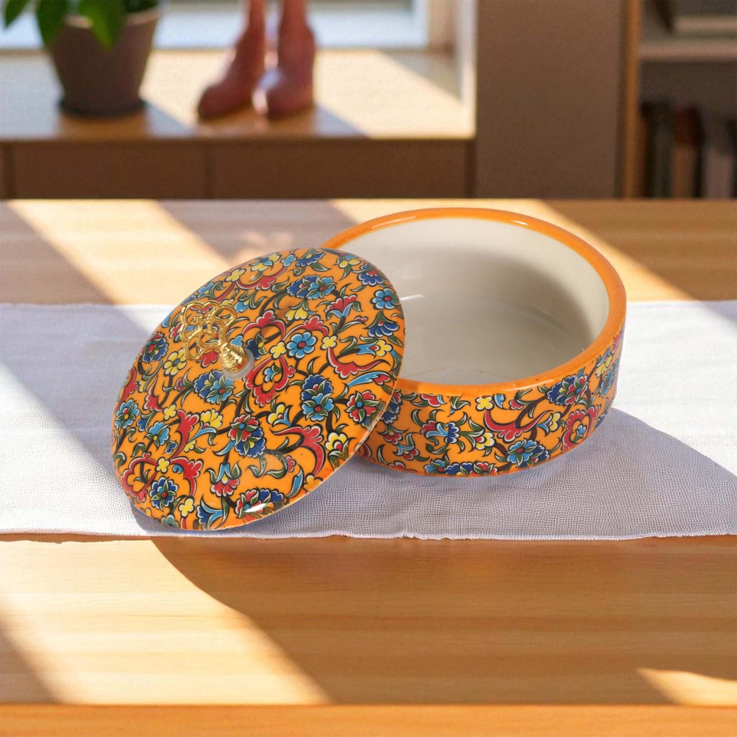 Decorative ceramic sugar bowl with floral pattern on a wooden table