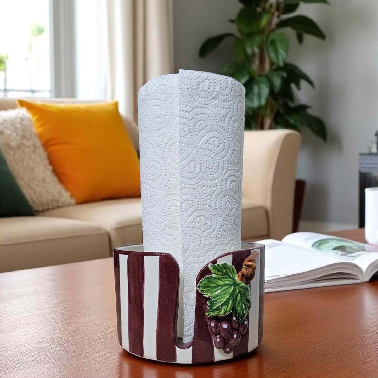 Roll of paper towels in a decorative paper towel holder on a table with a living room background