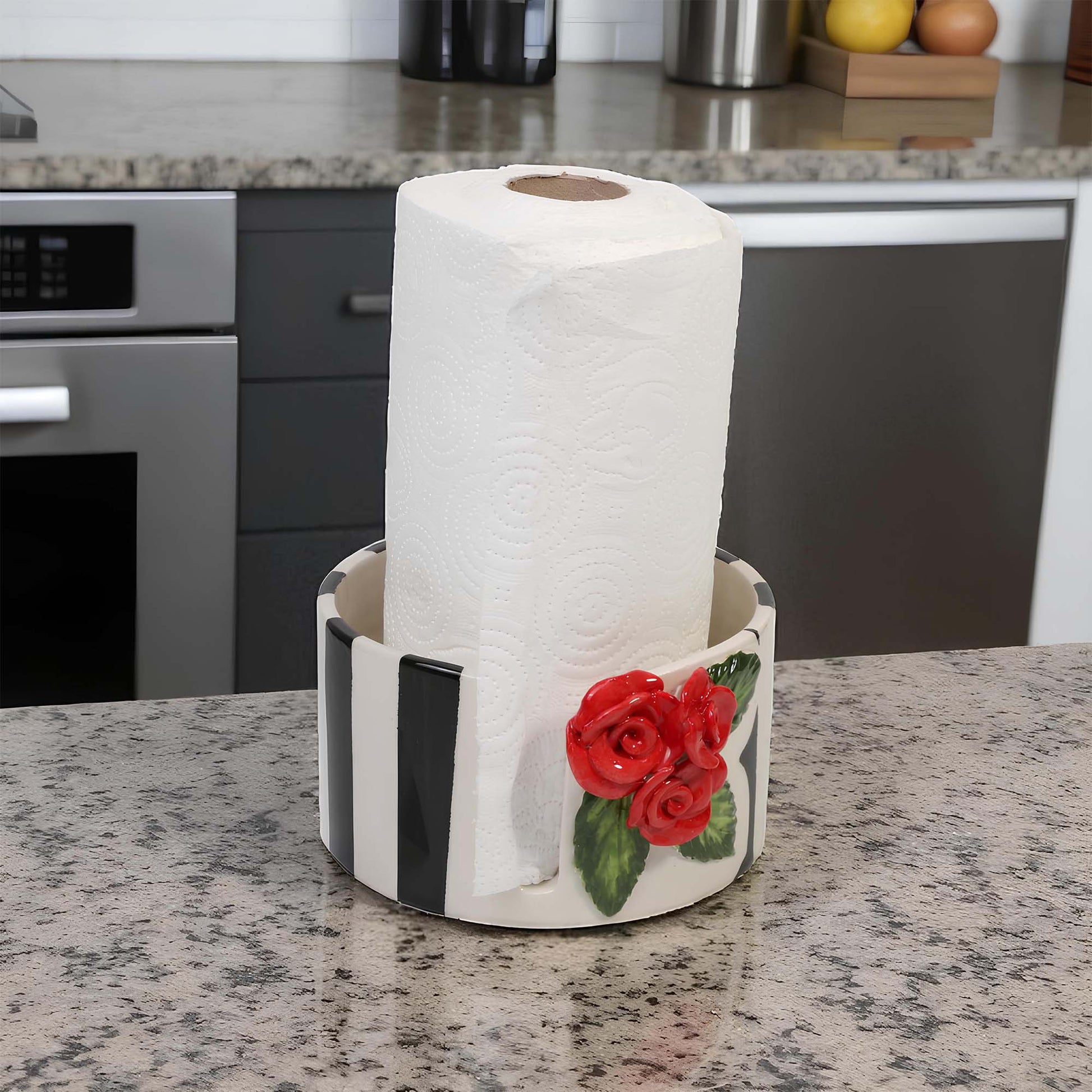 Roll of paper towels in a decorative paper towel holder with red roses on a kitchen counter.