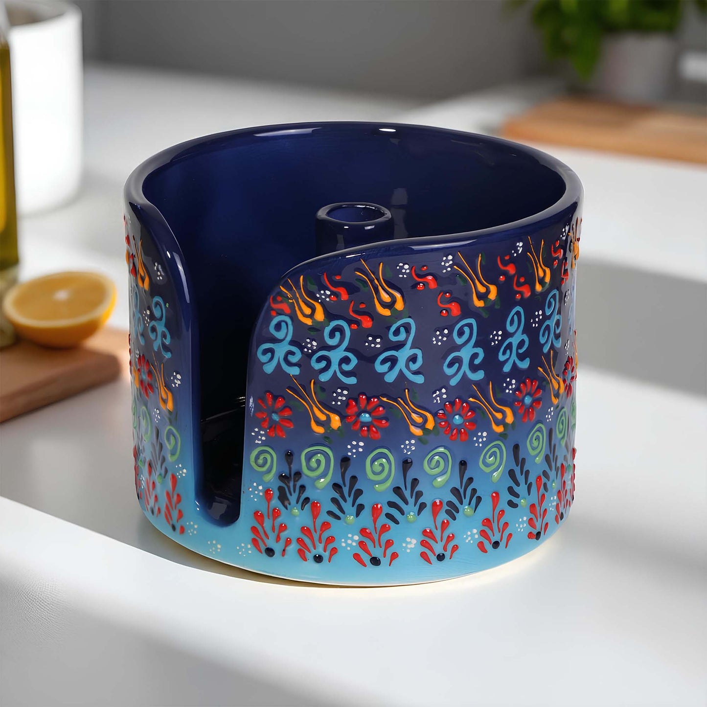 Decorative blue ceramic paper towel holder with colorful patterns on a kitchen counter.