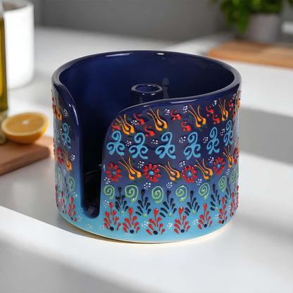 Decorative blue ceramic paper towel holder with colorful patterns on a kitchen counter.