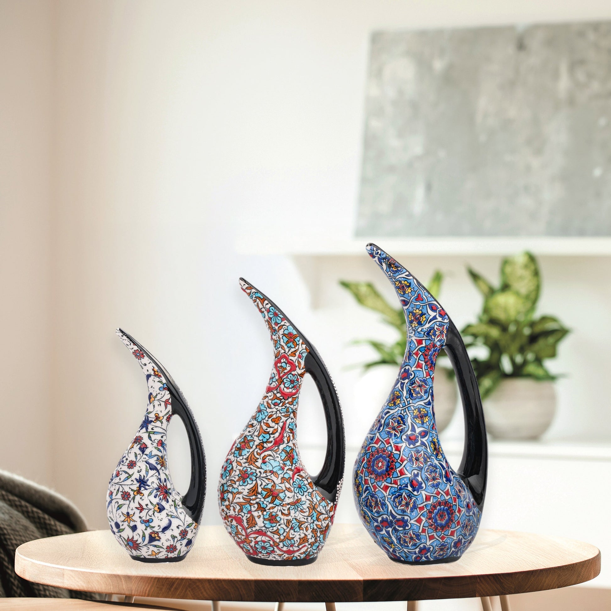 Set of 3 hand-painted ceramic ewers with Ottoman floral motifs in unique color palettes. Glossy artisan pieces with black handles, perfect décor or gifts.