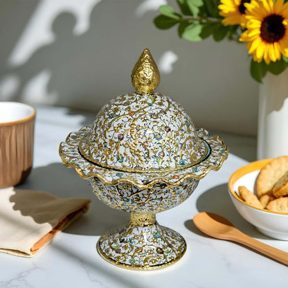Decorative sugar bowl with intricate design on a table with a cup, cookies, and sunflowers.