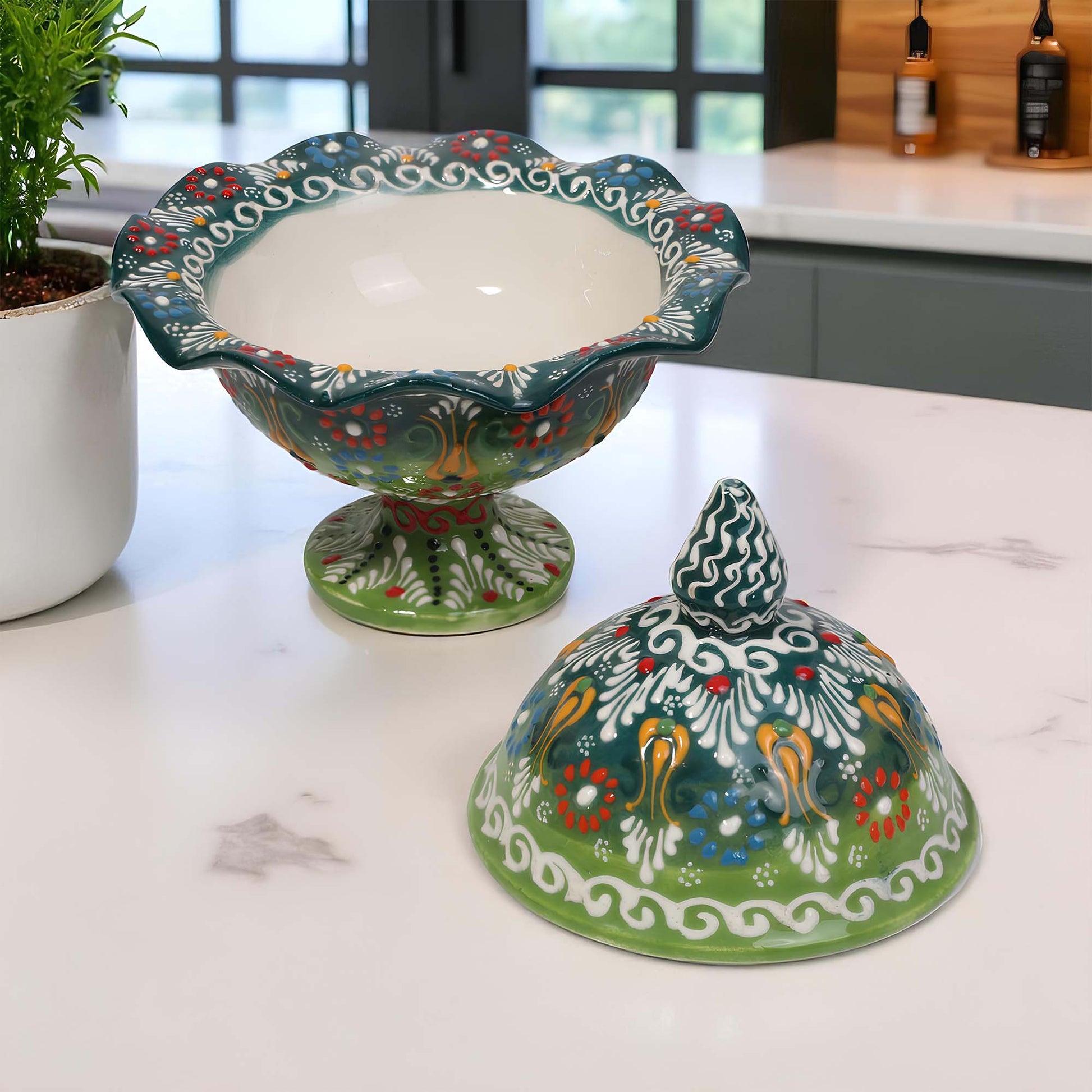 Decorative ceramic sugar bowl and cover with colorful patterns on a kitchen counter.