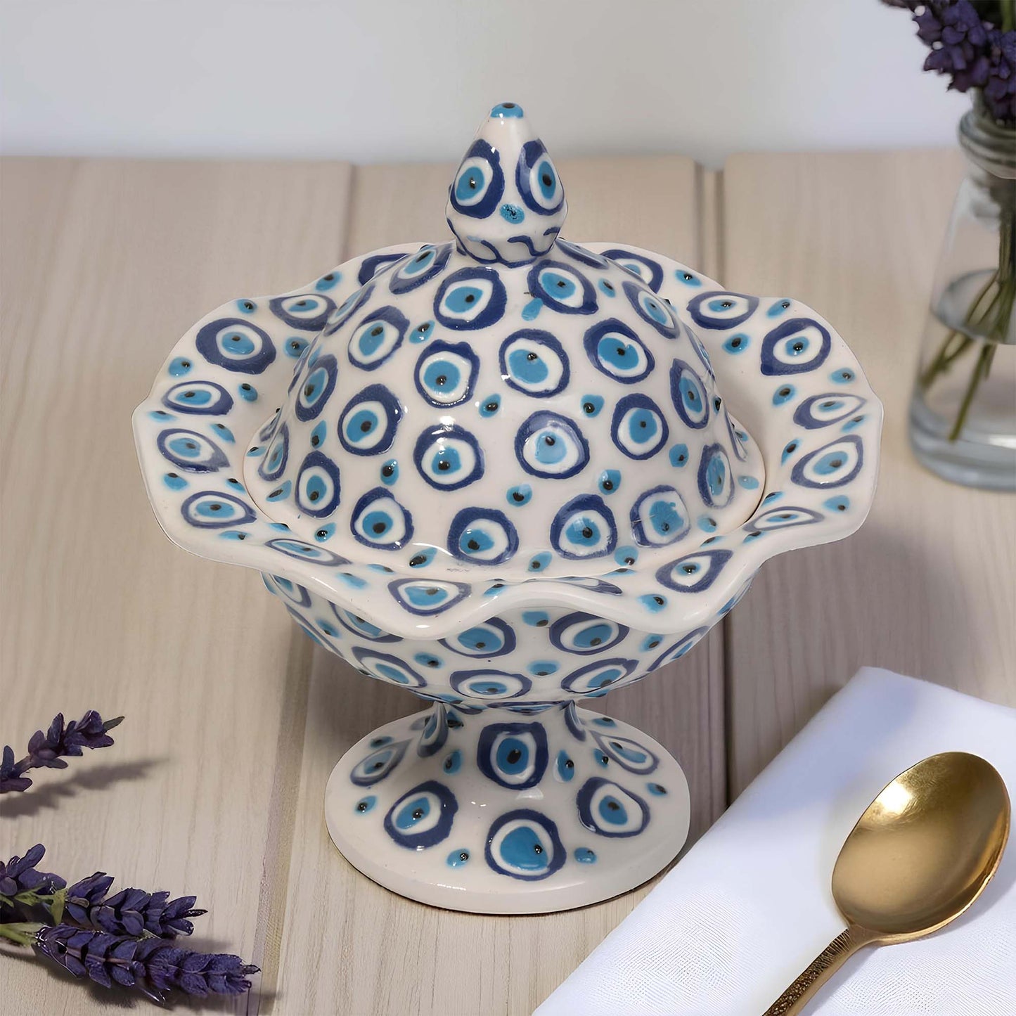 Ceramic sugar bowl with blue and white pattern on a wooden surface with lavender and a spoon.