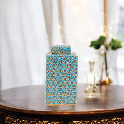 Hand-painted Golden Blossom ceramic jar with turquoise base and gold floral motifs. Square lidded design, artisan-made, perfect for décor, tea, or gifts.