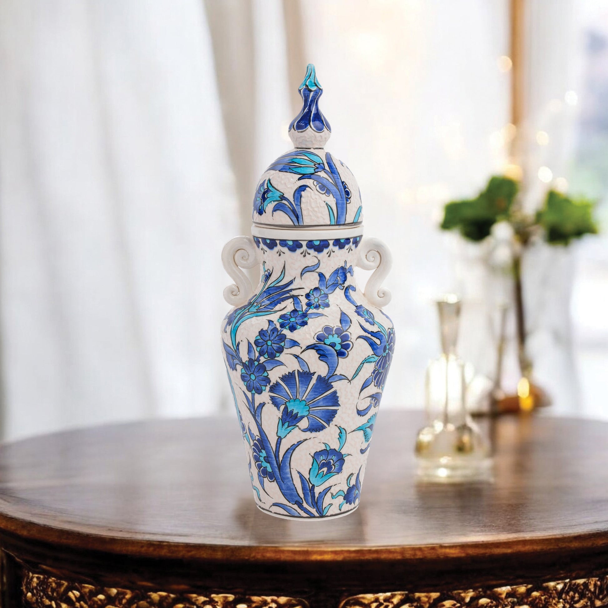 Hand-painted Azure Blossom ceramic jar with Turkish blue floral motifs and turquoise accents. Features handles and finial lid, perfect décor or collector’s gift.