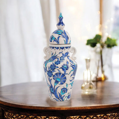 Hand-painted Azure Blossom ceramic jar with Turkish blue floral motifs and turquoise accents. Features handles and finial lid, perfect décor or collector’s gift.