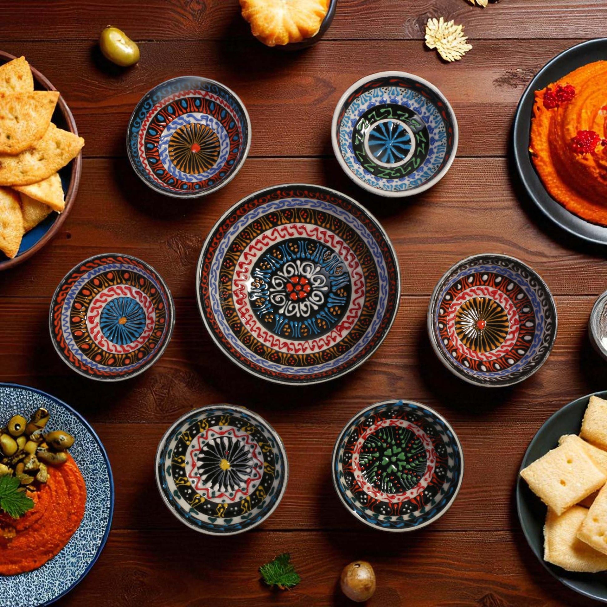 Decorative ceramic bowls with colorful patterns on a wooden table with food.