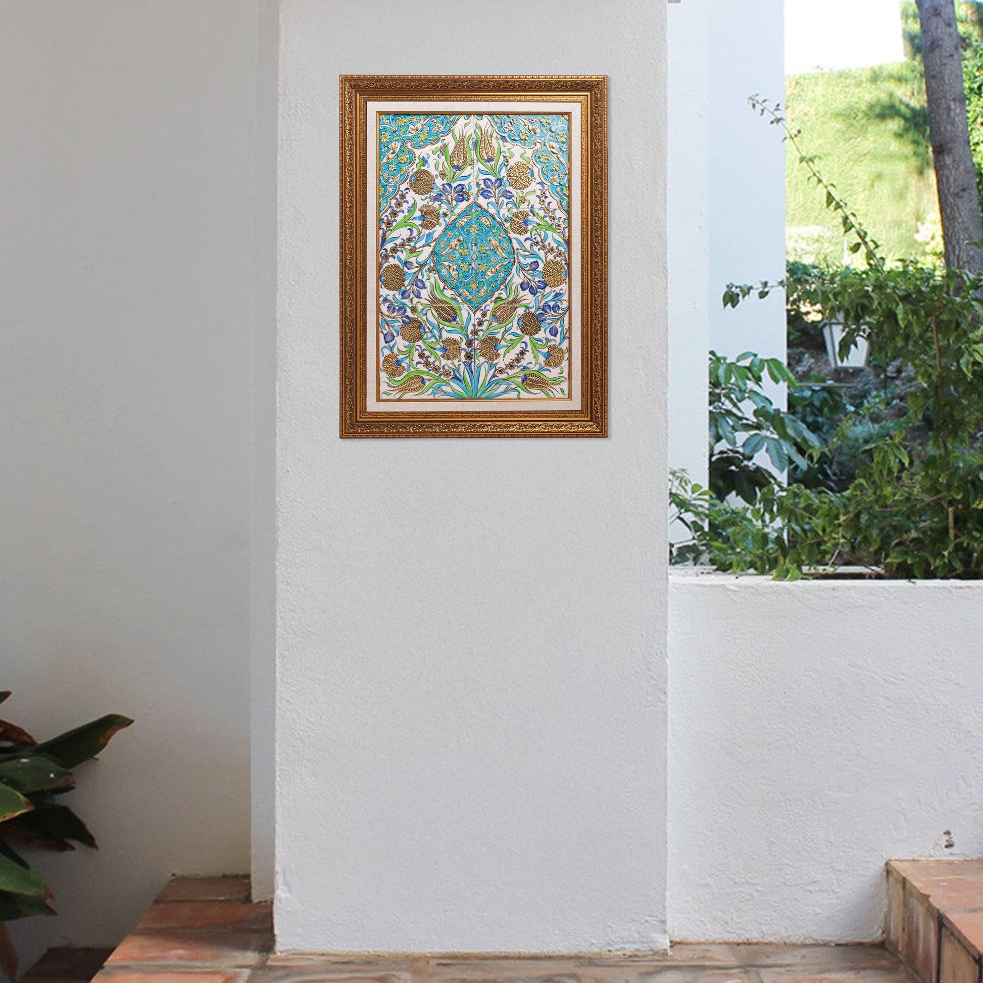 Decorative ceramic tile hanging on a white wall indoors with a view of greenery outdoors.