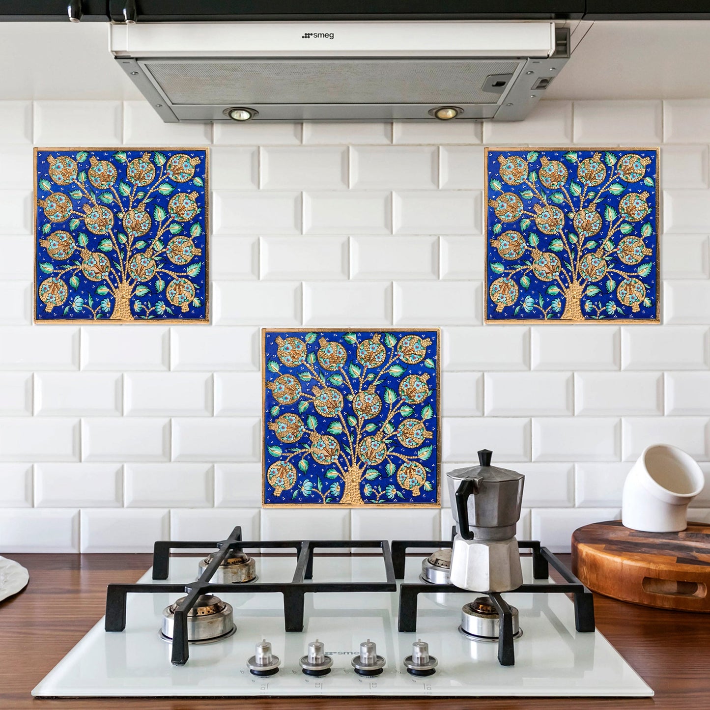 Decorative blue tree-of-life ceramic tiles on a white tiled kitchen backsplash.