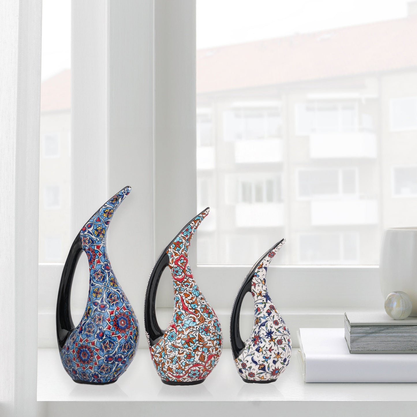 Set of 3 hand-painted ceramic ewers with Ottoman floral motifs in unique color palettes. Glossy artisan pieces with black handles, perfect décor or gifts.
