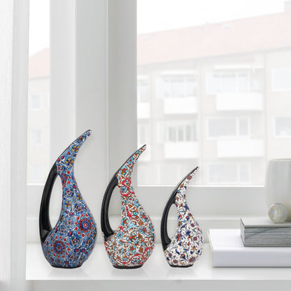 Set of 3 hand-painted ceramic ewers with Ottoman floral motifs in unique color palettes. Glossy artisan pieces with black handles, perfect décor or gifts.