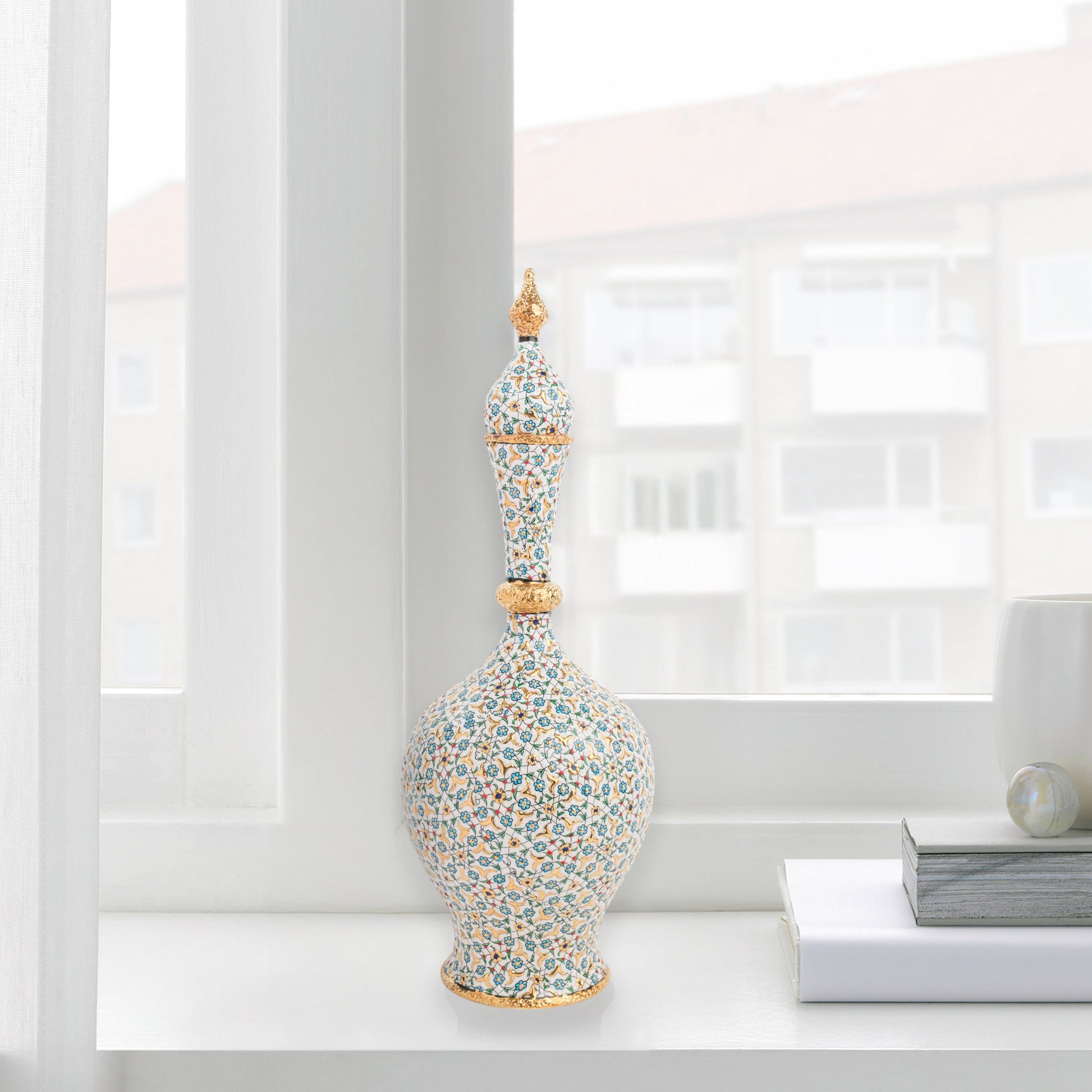 Hand-painted ceramic decorative bottle with turquoise floral motifs and golden details. Minaret-inspired shape with spire lid, perfect for décor or gifting.