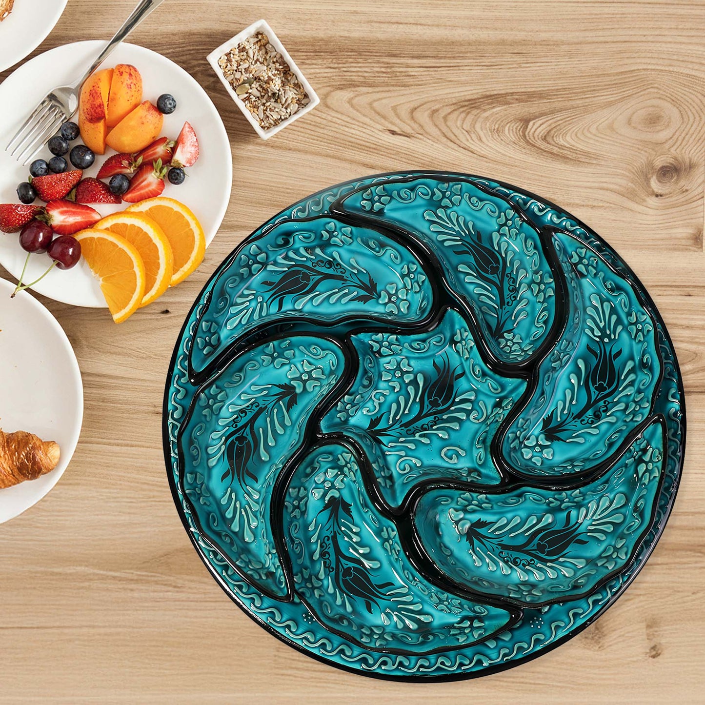Decorative blue snack serving tray set with black floral patterns on a wooden table with breakfast items.