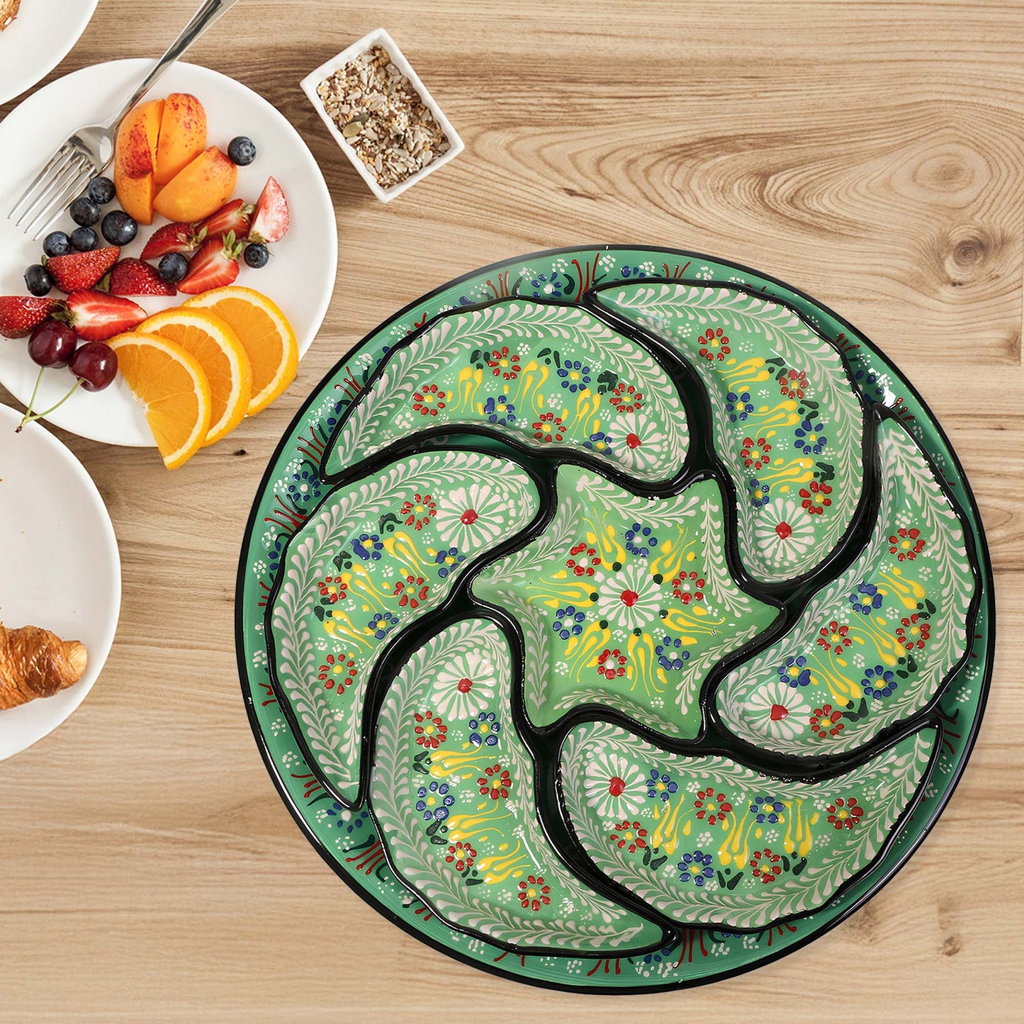Decorative ceramic snack serving tray set with floral patterns on a wooden table with breakfast items.