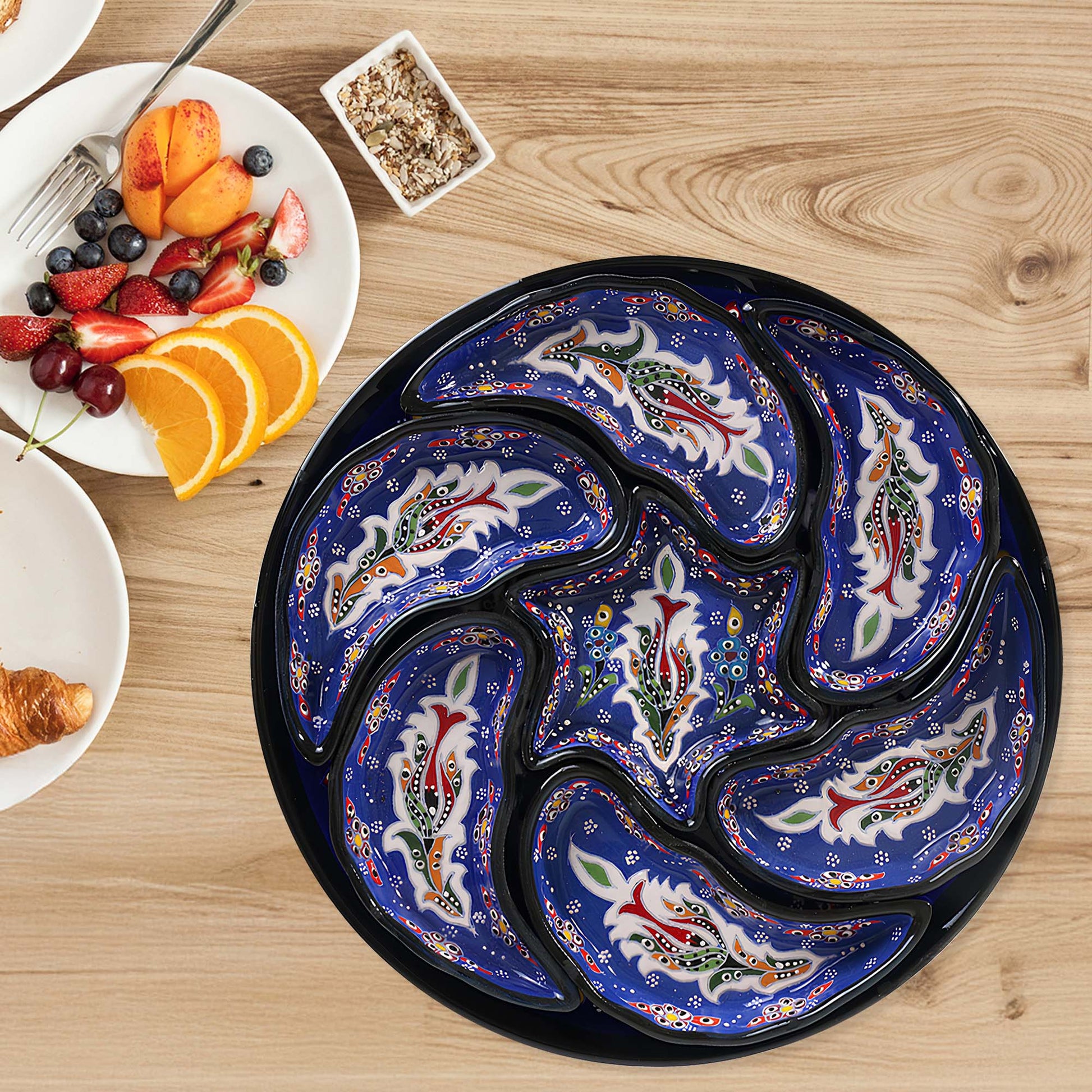 Decorative blue snack serving tray set with fish patterns on a wooden table with a breakfast setting.