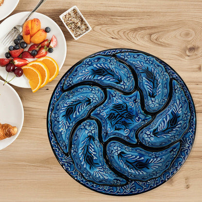 Decorative blue and black snack serving tray set with a tulip design on a wooden table with breakfast items.