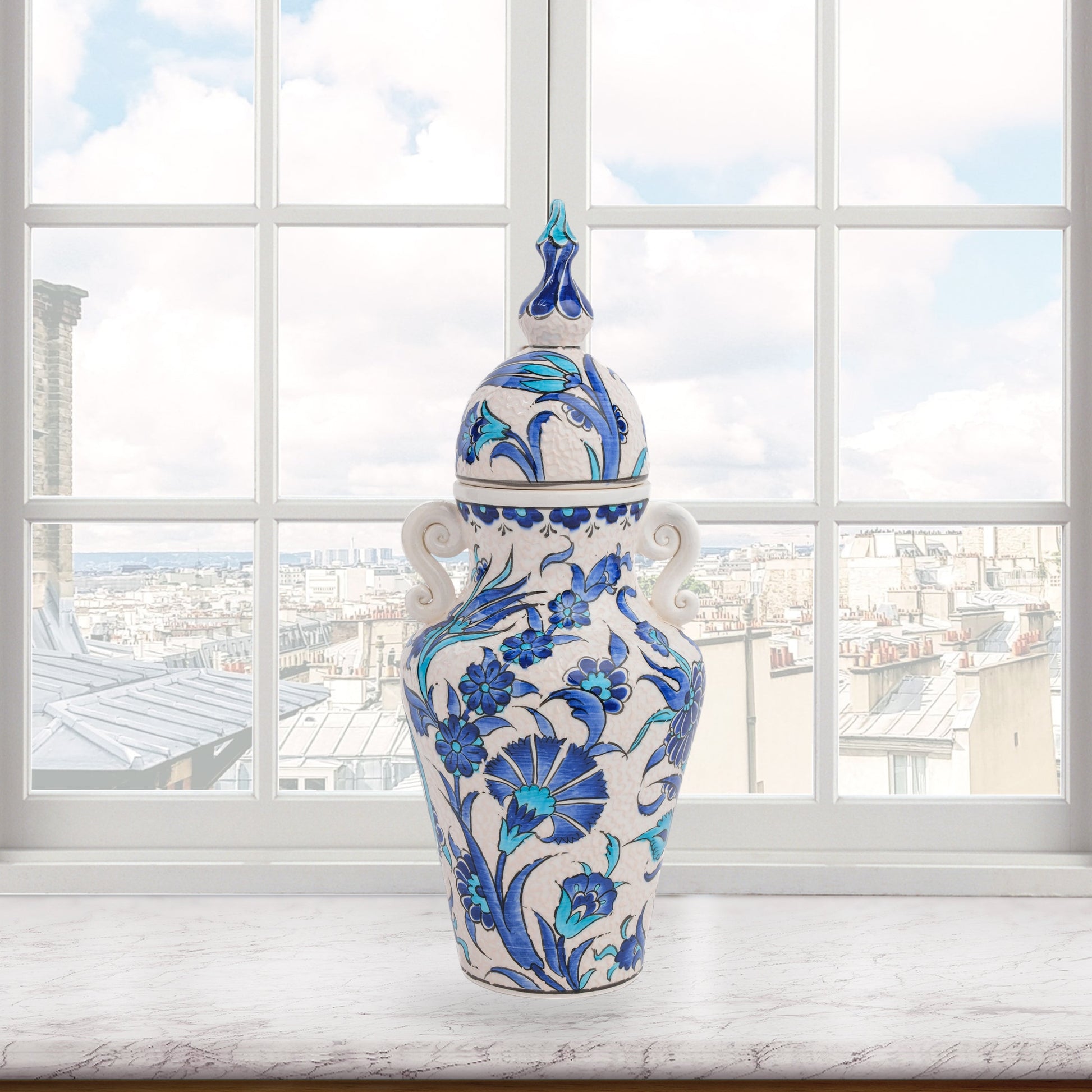 Hand-painted Azure Blossom ceramic jar with Turkish blue floral motifs and turquoise accents. Features handles and finial lid, perfect décor or collector’s gift.