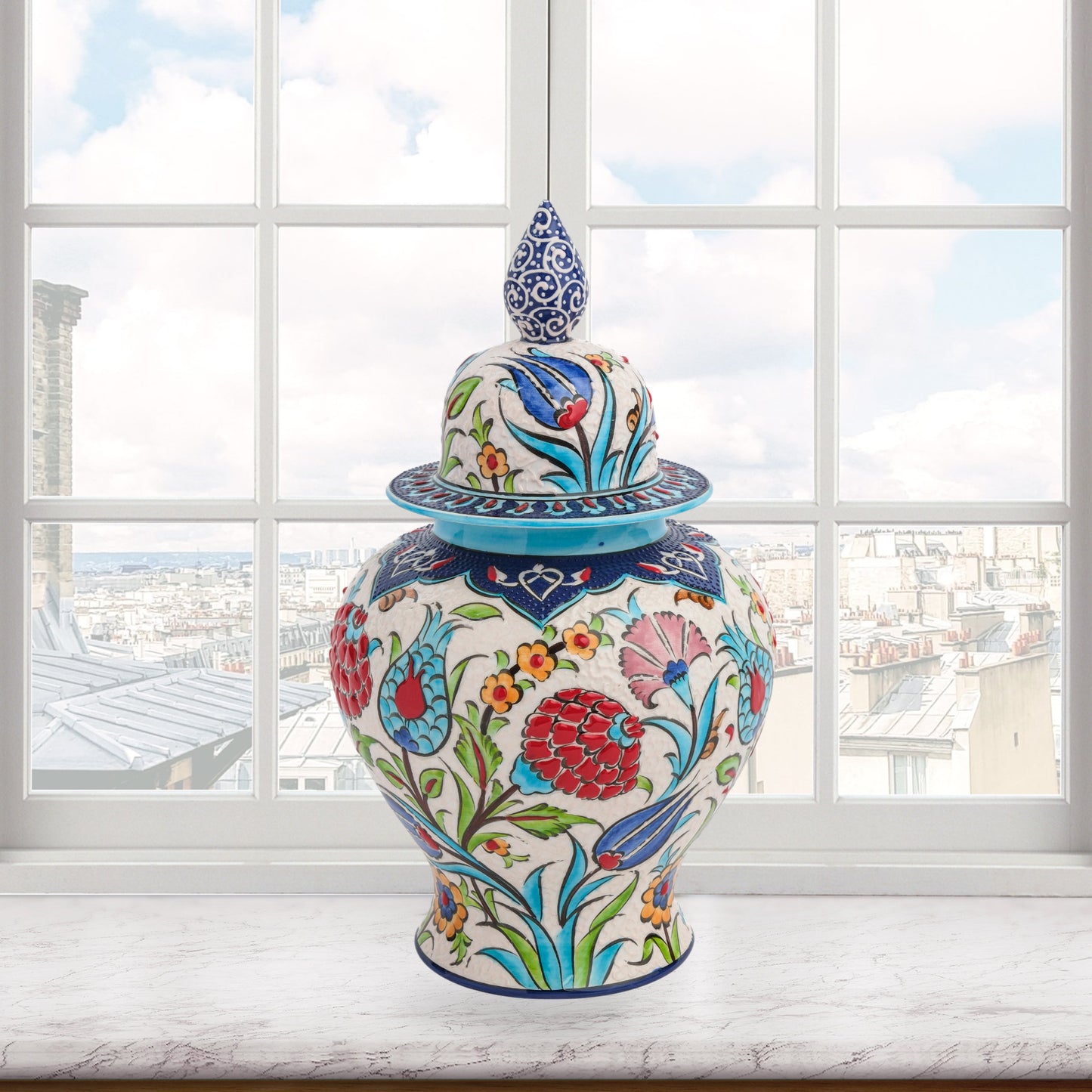 Hand-painted Floral Festival ceramic jar with red carnations, blue tulips & yellow blossoms. Glossy artisan jar with cobalt finial lid, perfect décor or gift.