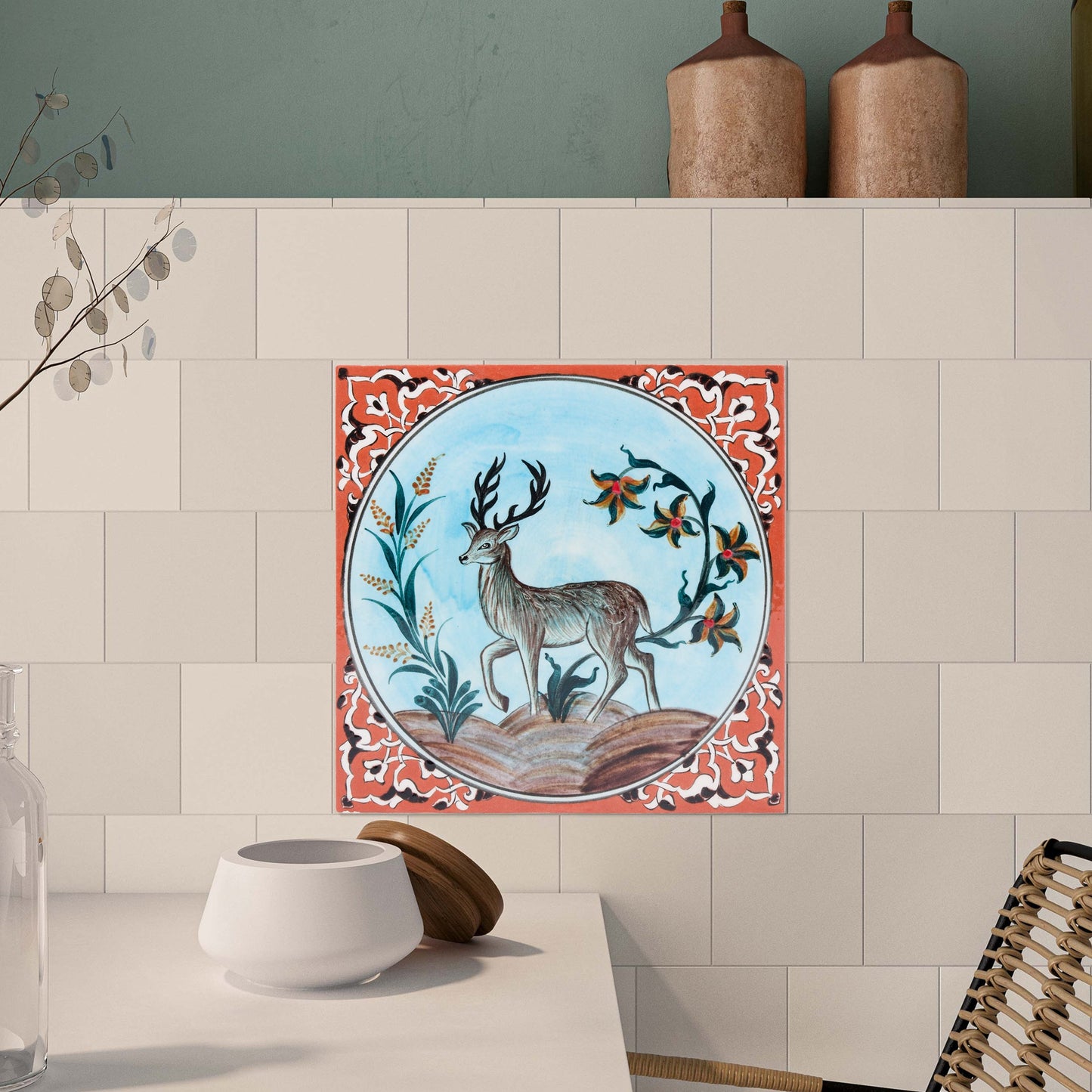 Decorative ceramic tile with deer design on a kitchen wall.