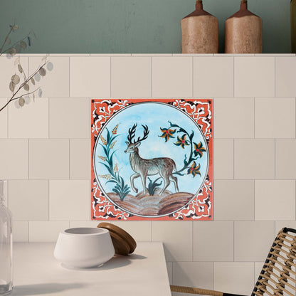 Decorative ceramic tile with deer design on a kitchen wall.