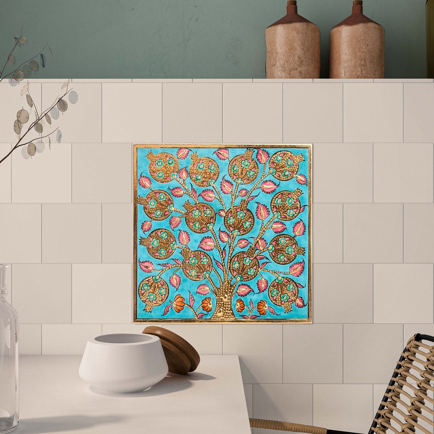 Colorful tree of life ceramic tile on a wall above a table.