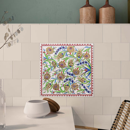 Decorative ceramic tile with floral pattern on a kitchen wall.