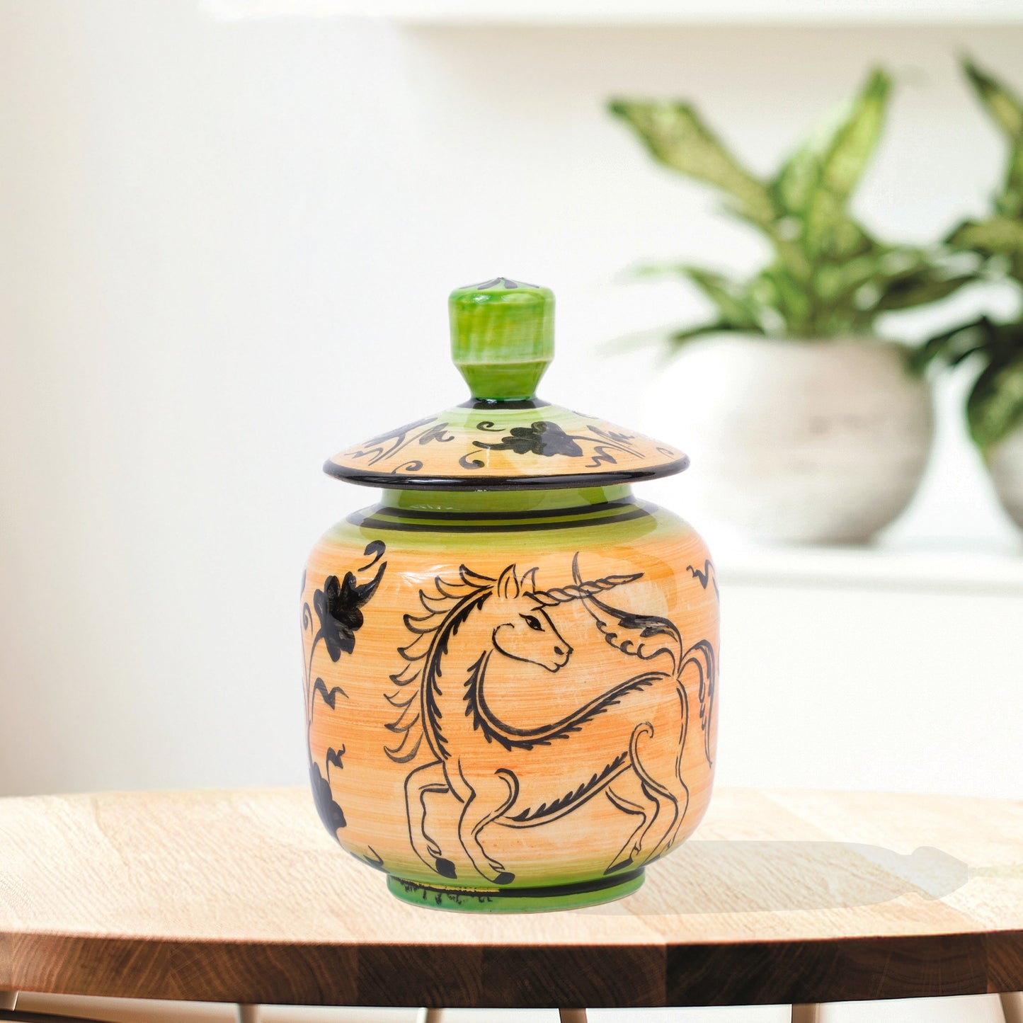 Hand-painted Unicorn Dance ceramic jar with whimsical black unicorn motif on orange & green. Lidded artisan jar, perfect for honey, ginger, spices, or décor.