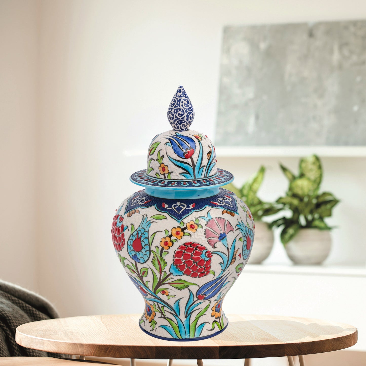 Hand-painted Floral Festival ceramic jar with red carnations, blue tulips & yellow blossoms. Glossy artisan jar with cobalt finial lid, perfect décor or gift.