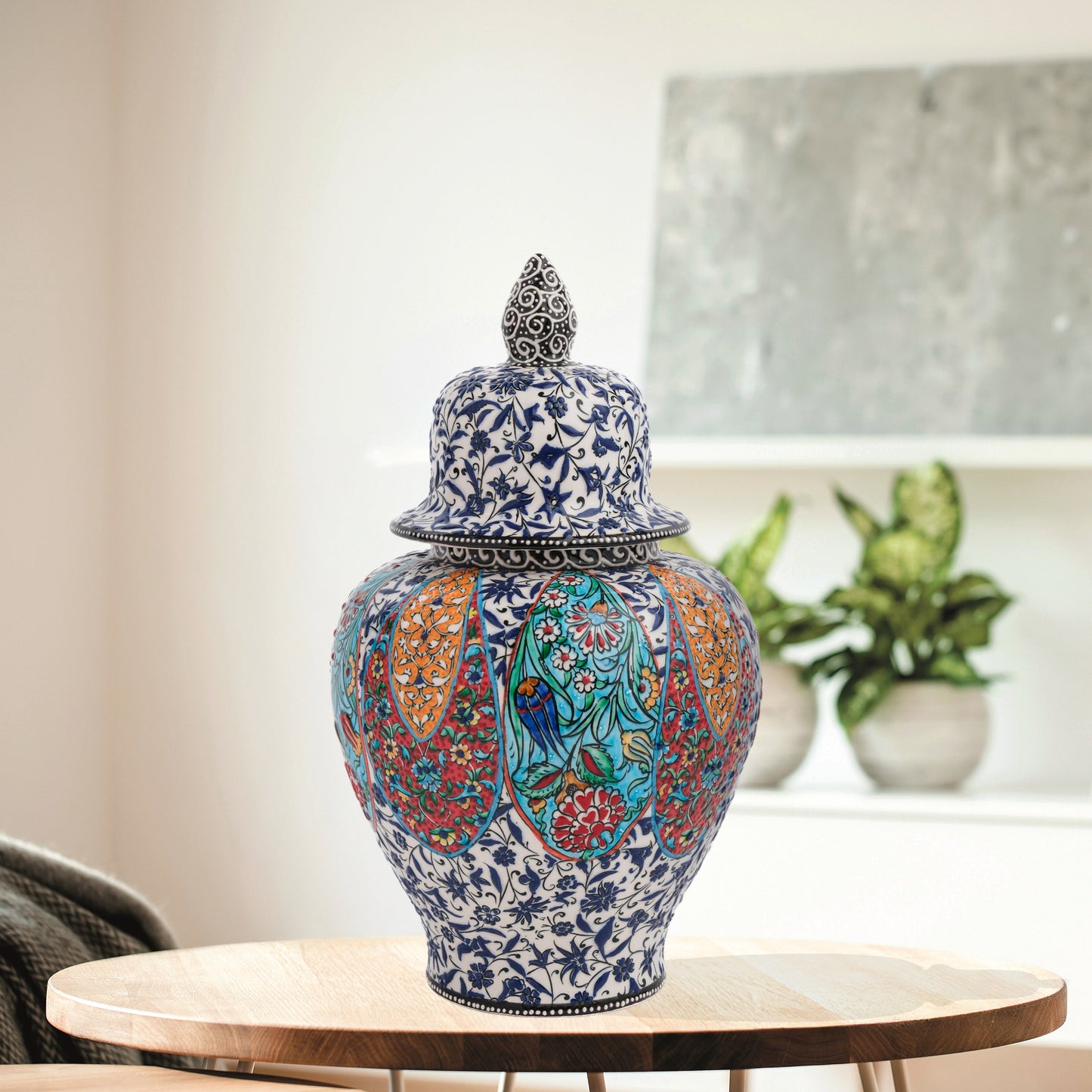 Hand-painted Garden Song ceramic jar with floral and bird motifs in vibrant panels. Lidded artisan jar with ornate finial, perfect décor accent or gift.