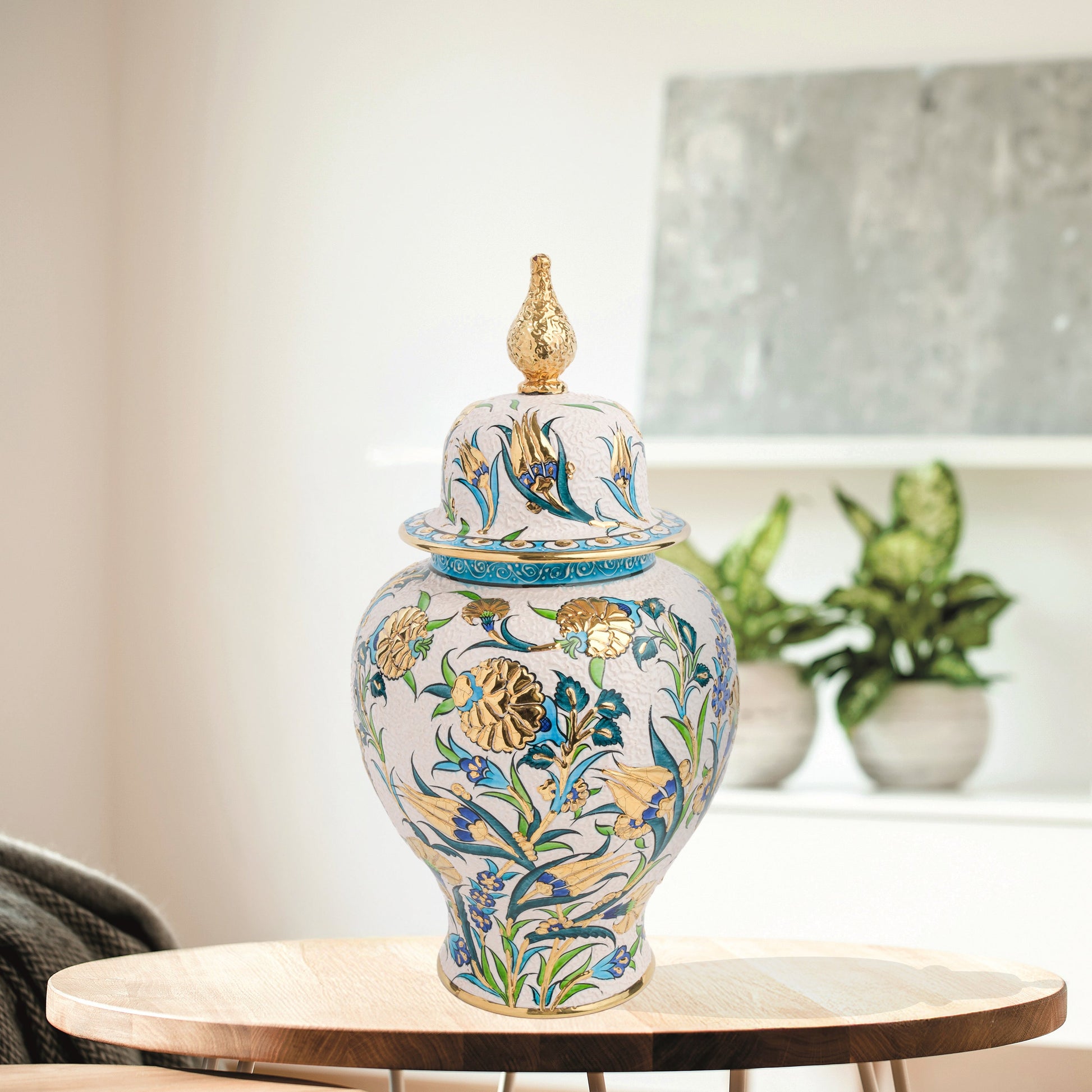 Hand-painted Golden Bloom ceramic jar with blue tulips, green leaves & gold accents. Finished with sculpted golden finial, artisan-made, perfect décor or gift.