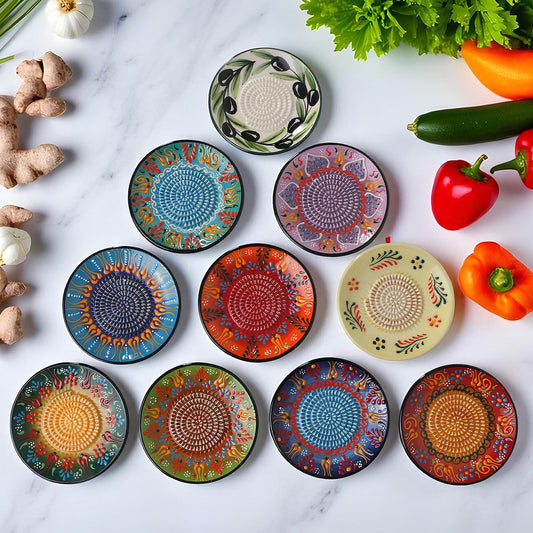 Set of colorful ceramic garlic graters on a marble surface with vegetables.