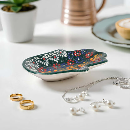 Decorative leaf-shaped trinket dish with jewelry on a table
