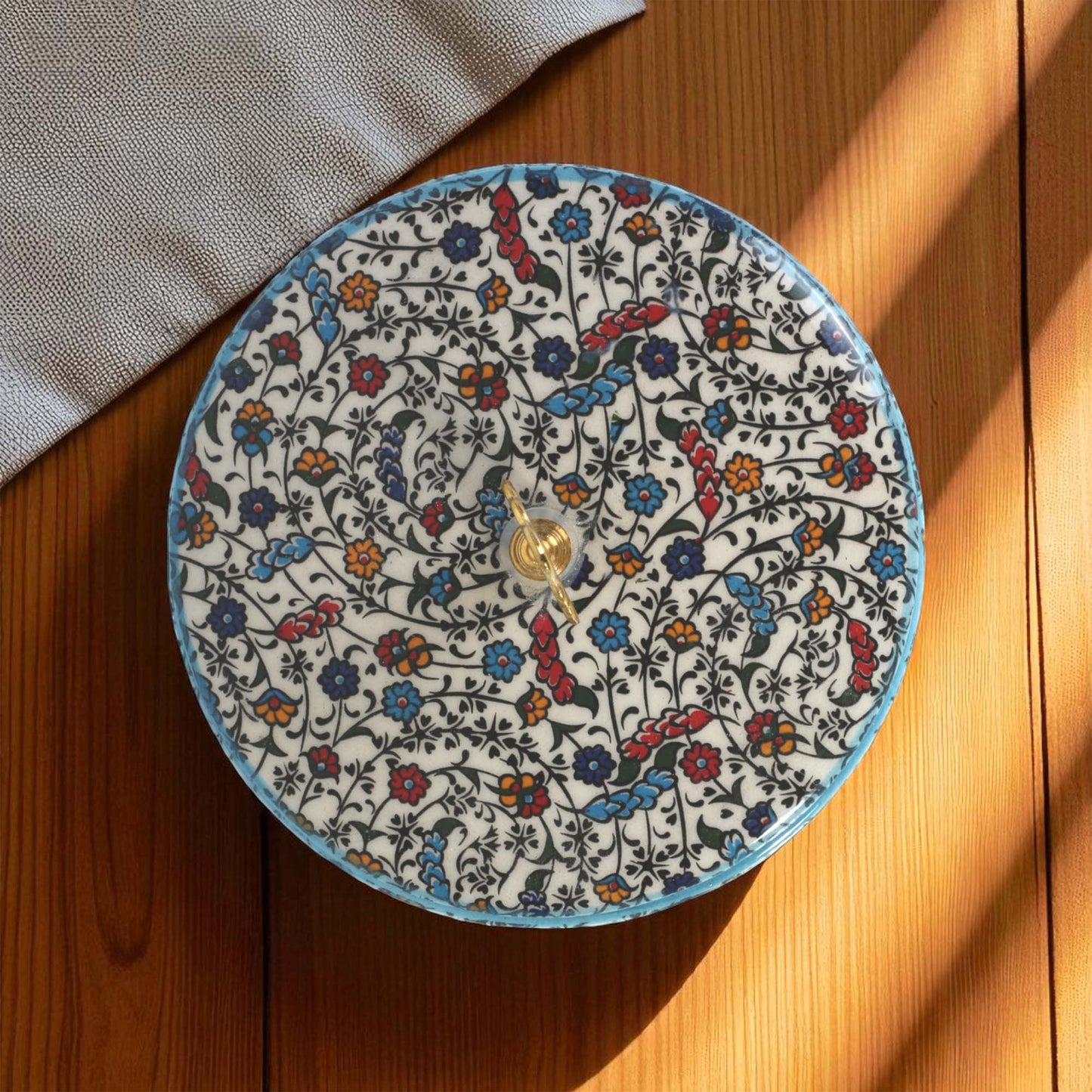 Decorative sugar bowl with floral pattern on a wooden surface