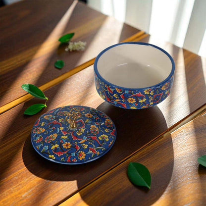 Decorative blue sugar bowl with floral patterns on a wooden surface