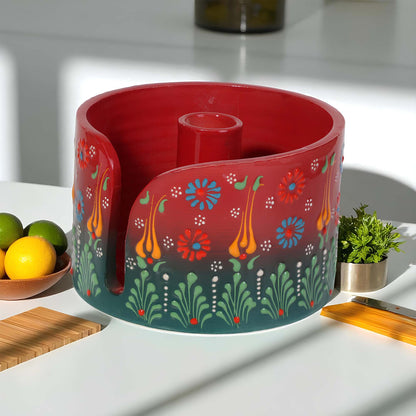 Decorative red paper towel holder with floral patterns on a kitchen counter