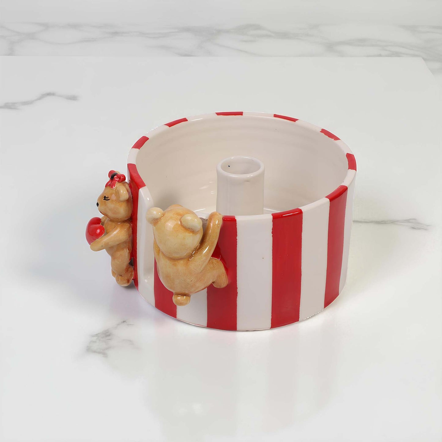 Ceramic paper towel holder with red and white stripes and bear figures on a marble surface