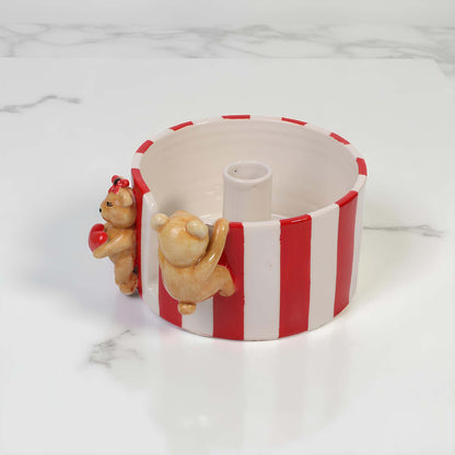Ceramic paper towel holder with red and white stripes and bear figures on a marble surface
