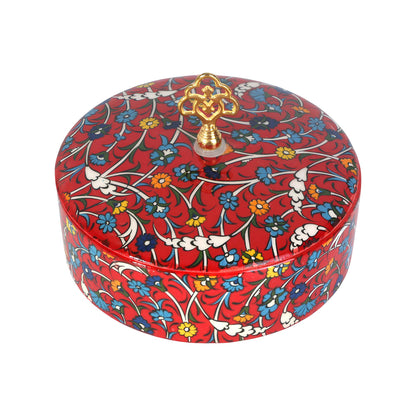 Decorative sugar bowl with floral pattern and gold lid finial on a white background