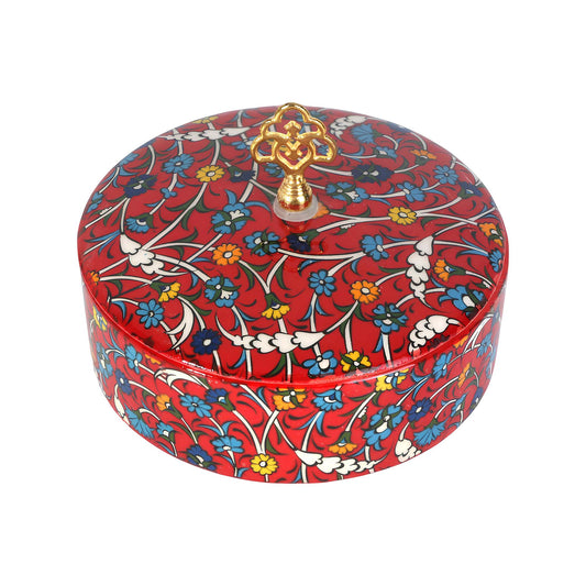 Decorative sugar bowl with floral pattern and gold lid finial on a white background