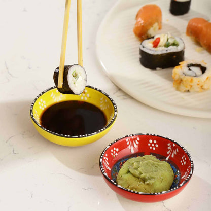 Sushi being dipped into soy sauce with wasabi on a side, on a light background