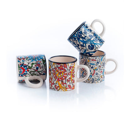 A set of four ceramic espresso cups with floral and geometric patterns in blue, red, and white colors.