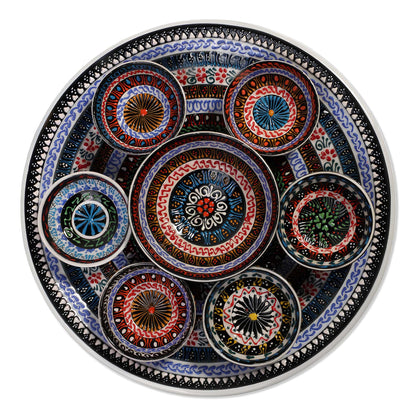 Decorative ceramic plate with colorful circular bowls on a white background