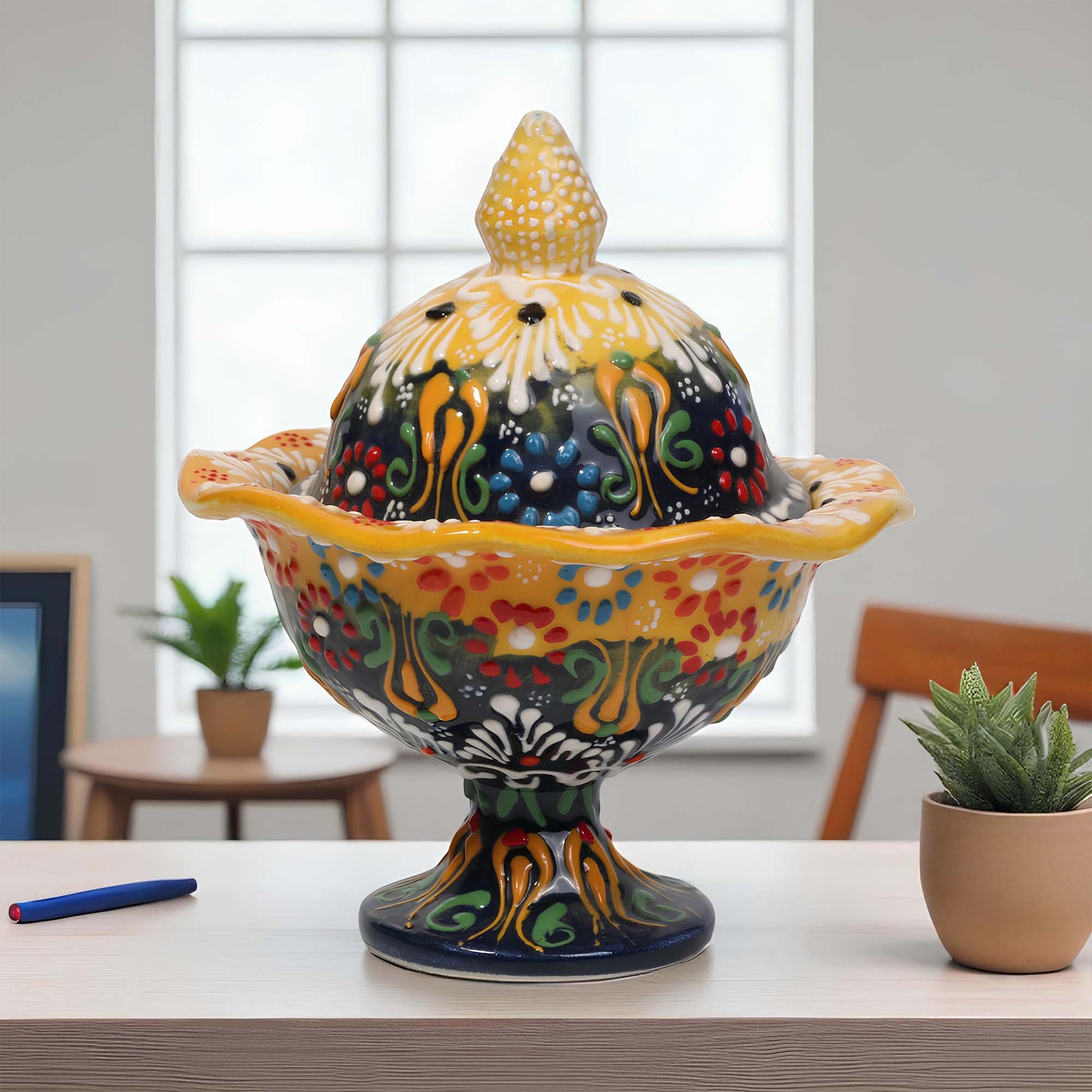 Colorful ceramic sugar bowl with intricate designs on a table.