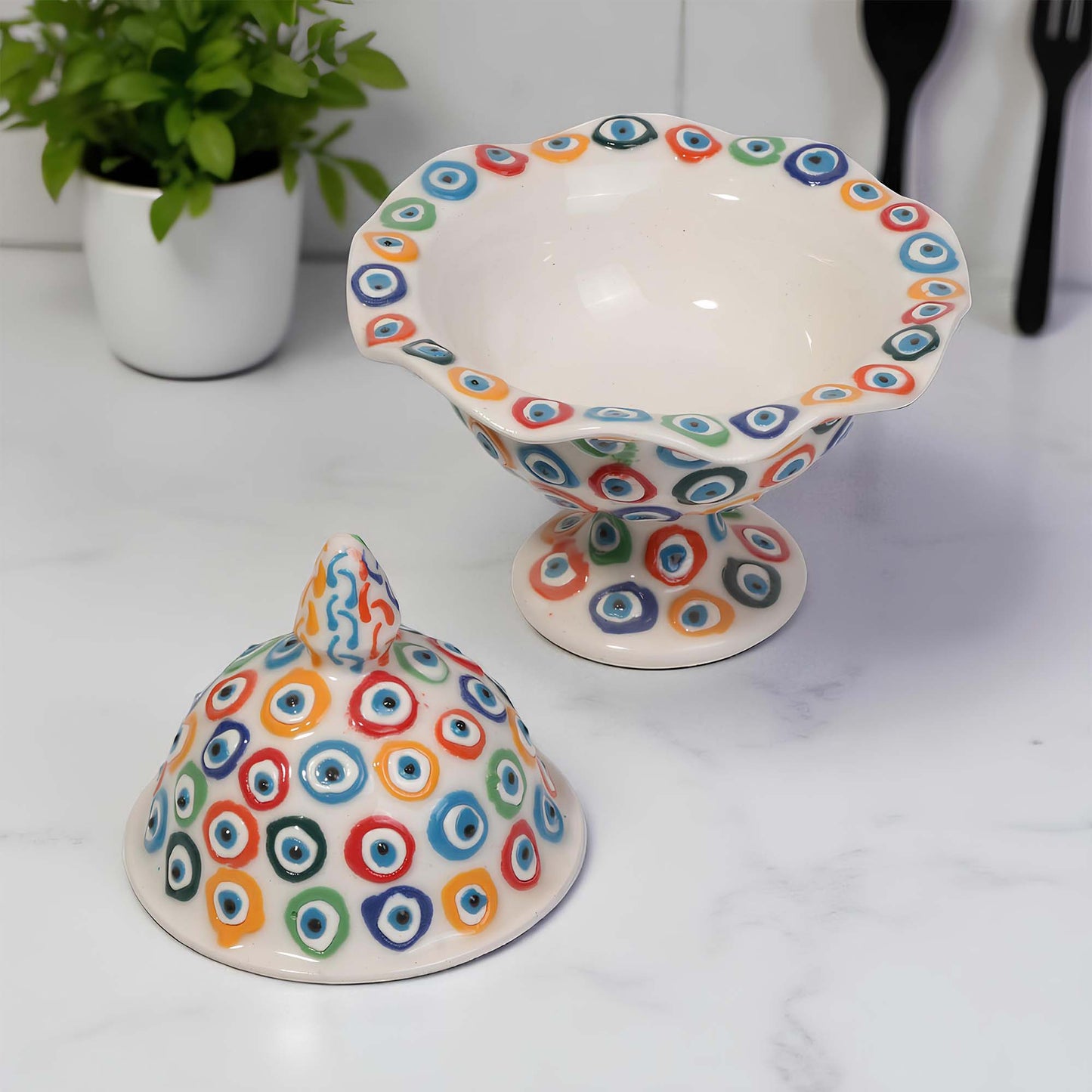 Ceramic sugar bowl with colorful circular pattern on a white surface.