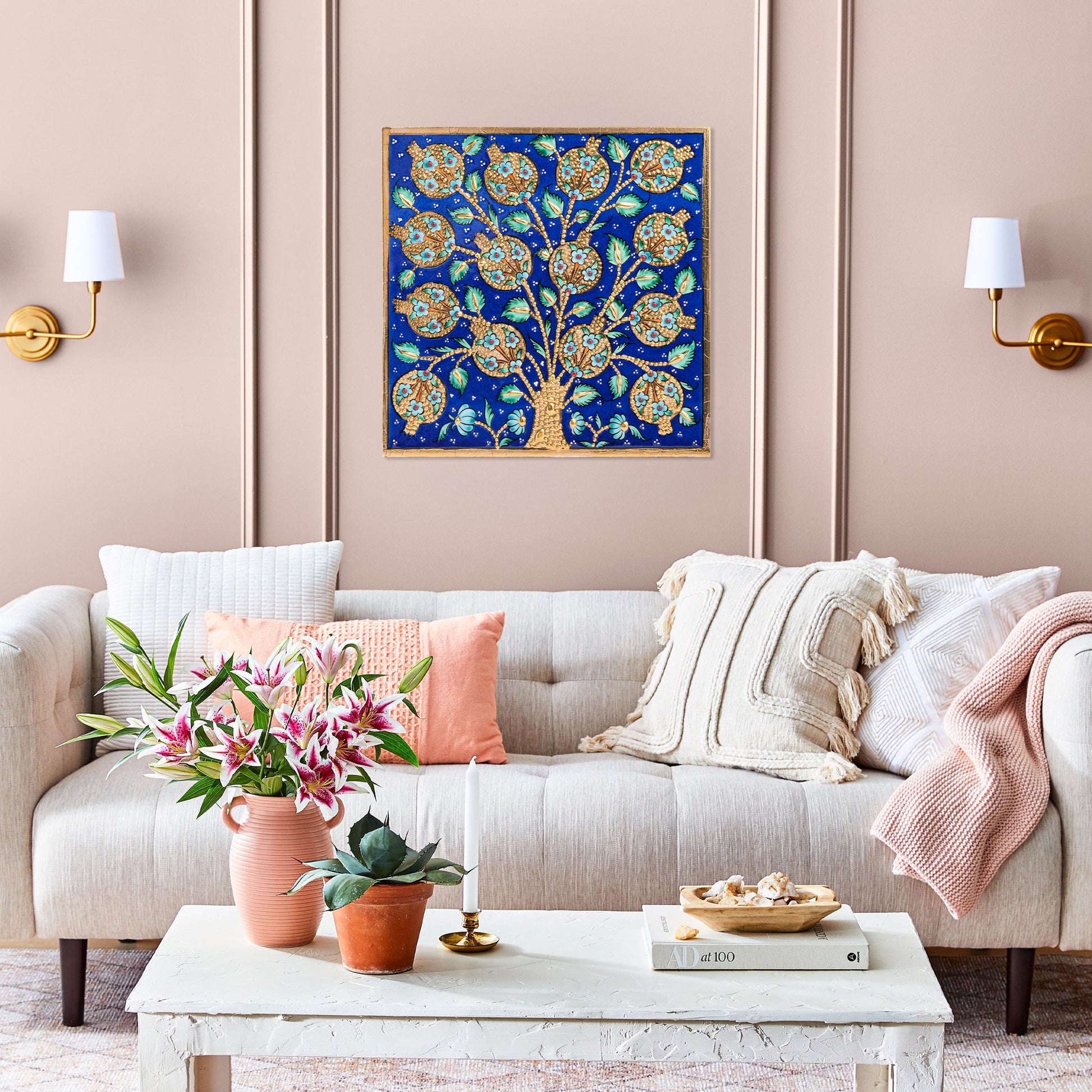 Decorative living room with a tree of life ceramic tile on a pink wall.