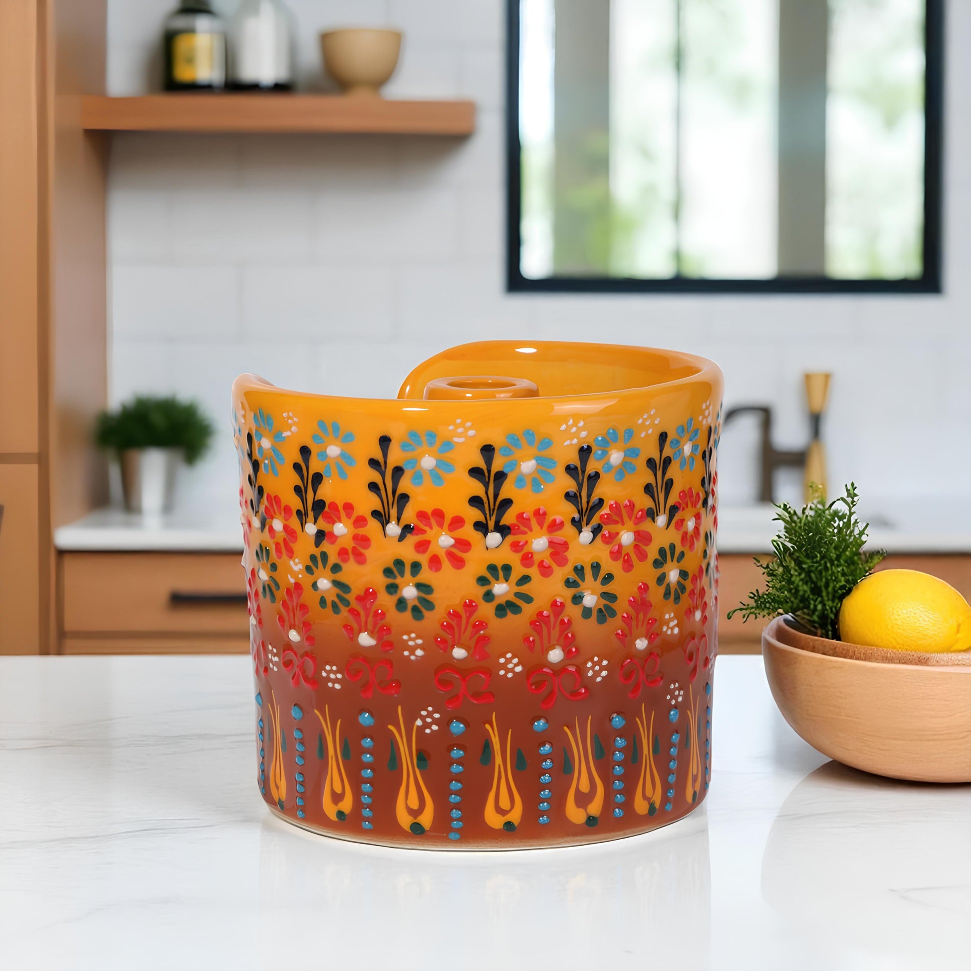 Decorative orange paper towel holder with floral pattern on a kitchen counter