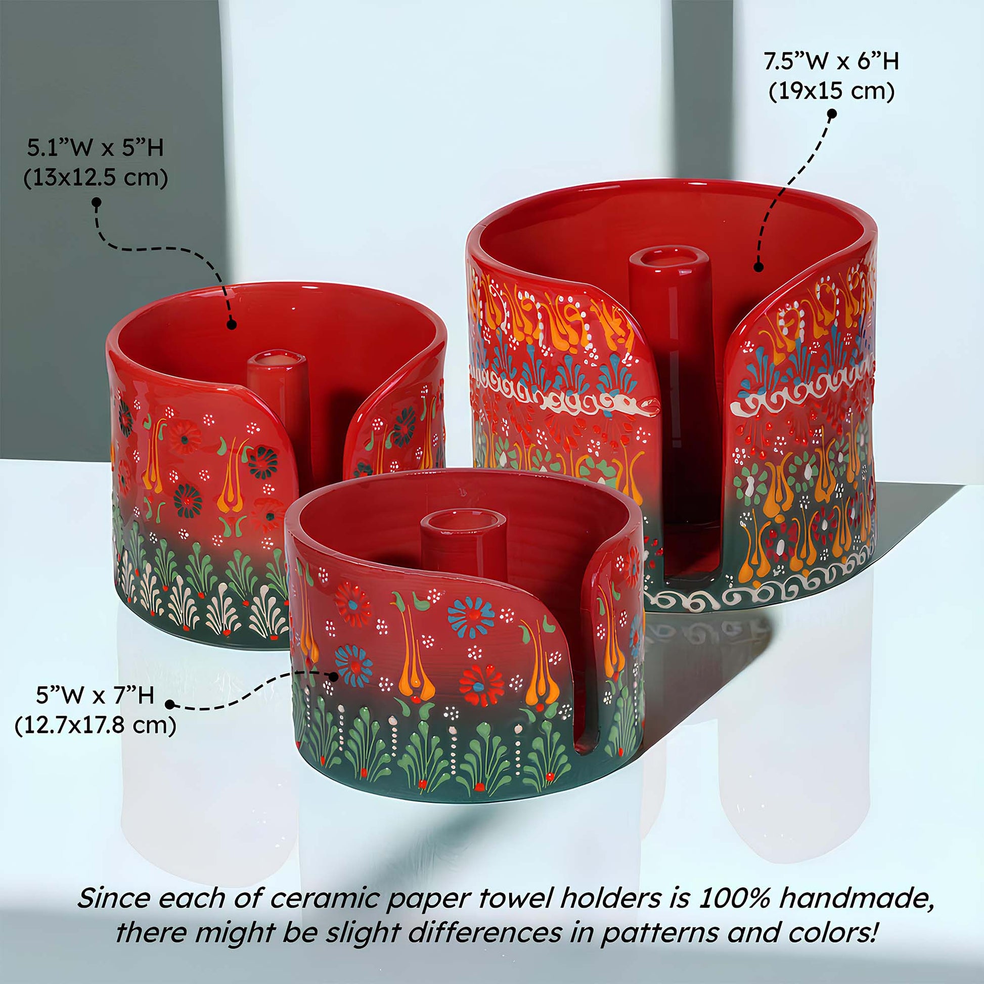 Set of three red ceramic paper towel holders with floral patterns on a white background.