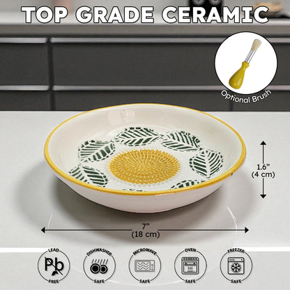 Ceramic garlic grater bowl with leaf pattern on a white surface, featuring dimensions and safety icons.